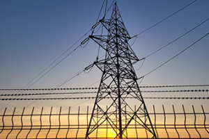 Transmission line at sunset with fence_Canva.png