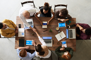 aerial shot of employees meeting around table_Canva.png
